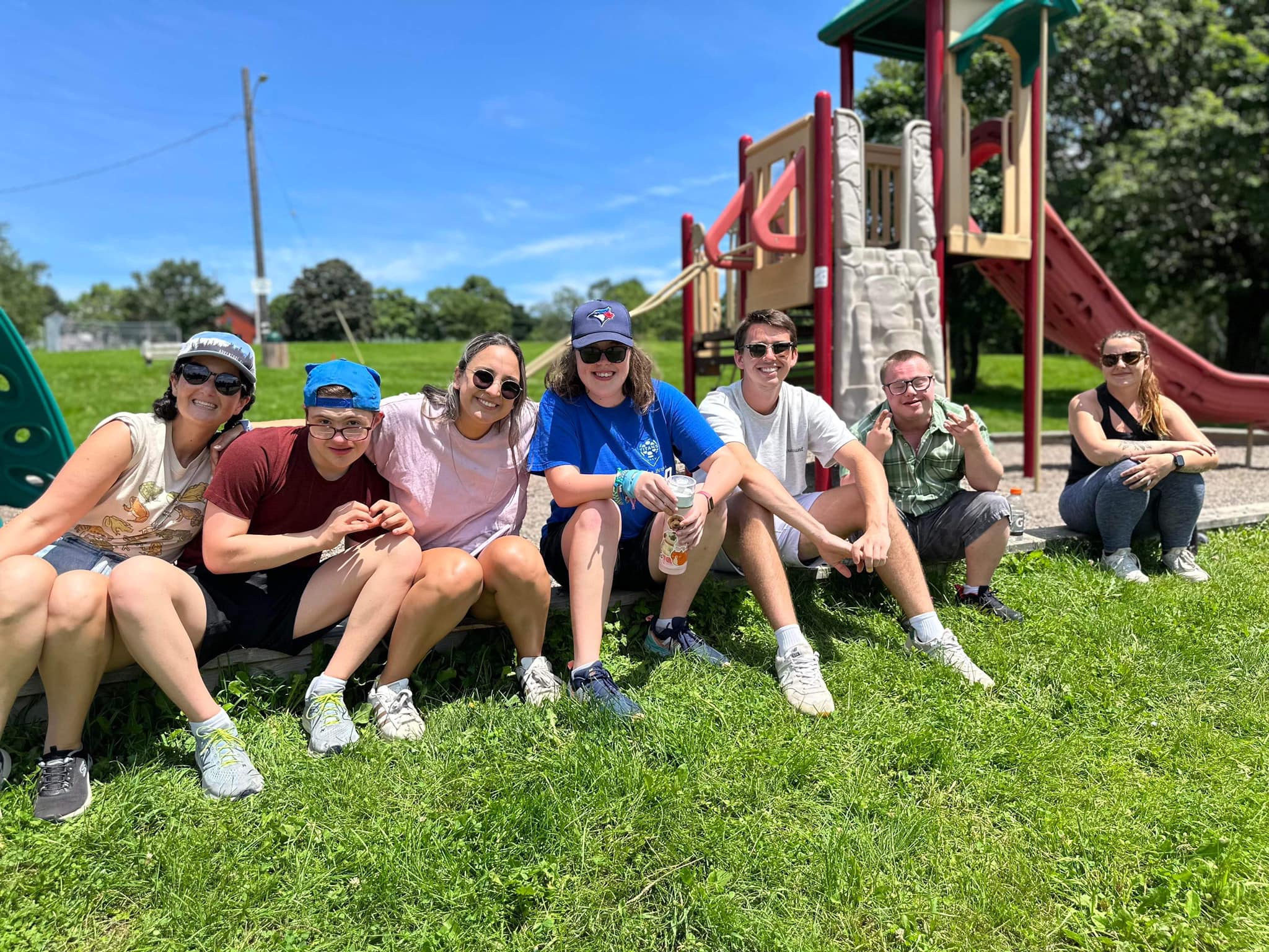 club inclusion members sitting outside together at a park